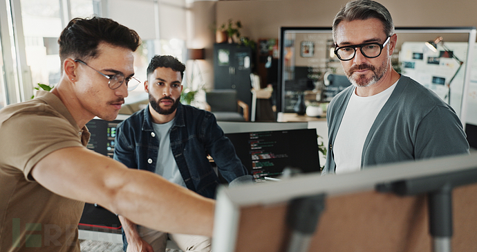 办公室内程序员与商务人士进行网站开发规划讨论